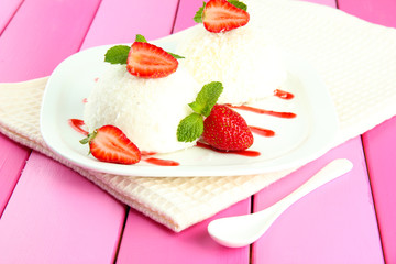 Delicious coconut cakes on plate on table close-up