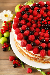 Tasty cake with fresh berries on wooden table