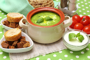 Tasty soup in saucepan on tablecloth, close up