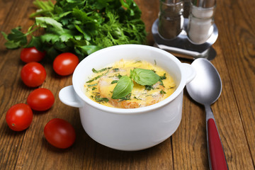 Tasty soup in saucepan on wooden table, close up