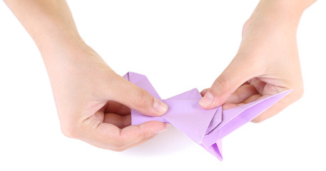 Obraz na płótnie Canvas Hands making origami toy, close up, isolated on white