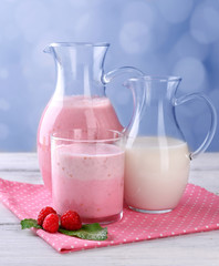 Glass jug of milk cocktail with raspberry taste