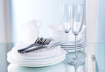Set of white dishes on table on light background