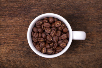 cup of coffee beans on the brown wooden background