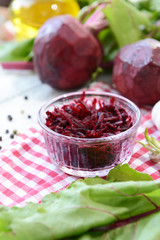 Grated beetroots in bowl on table close-up