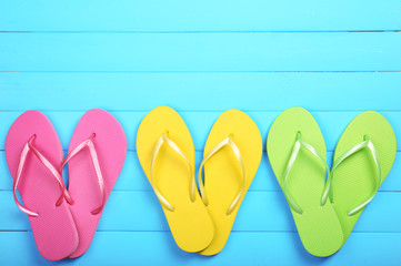 Bright flip flops on wooden background