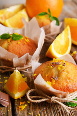 Tasty cupcakes with orange on table close-up
