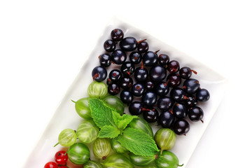 Forest berries on plate, isolated on white