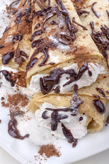 Pancakes with whipped cream topped with chocolate
