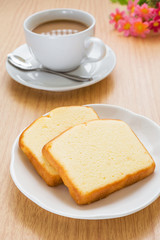 Fototapeta na wymiar Butter cake sliced on plate and coffee cup