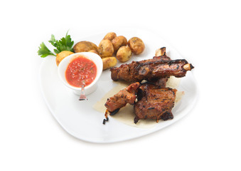 the ribs on the grill with potatoes and sauces