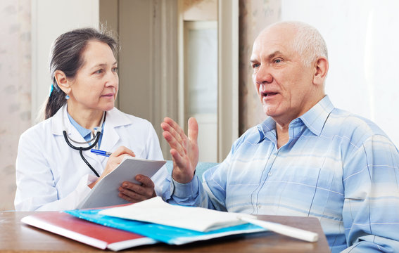 mature doctor talks with  senior man