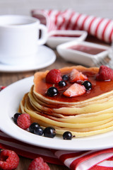 Sweet pancakes with berries on table close-up