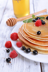 Sweet pancakes with berries on table close-up