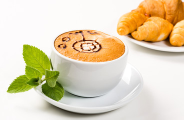 large cup of coffee and croissants on a plate
