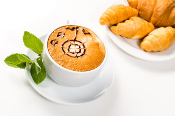 large cup of coffee and croissants on a plate