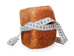 White tape measure wrapped around whole wheat bread