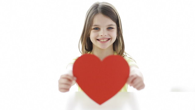 smiling girl with red heart at home
