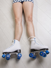 Woman laying on floor wearing quad skates
