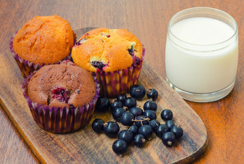 three muffins with blackcurrant and a glass of milk