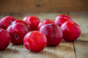 red plums on old wooden background