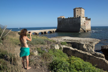 girl taking picture of torre astura castle