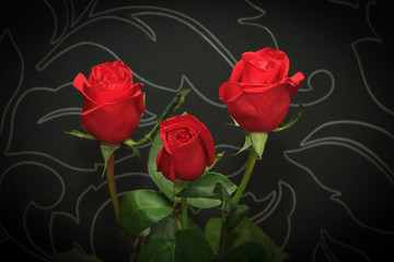 Three red roses over black backround