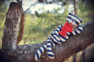 Cute toy cat resting on a tree