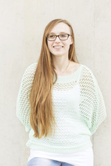 junge Frau mit langen roten Haaren und Brille