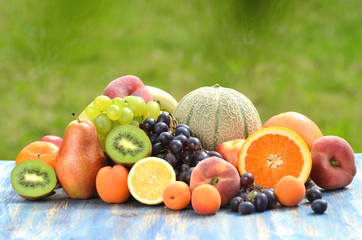 mieszanka różnych owoców na stole w ogrodzie - obrazy, fototapety, plakaty