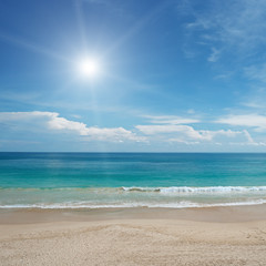 Sandy beach and sun in blue sky