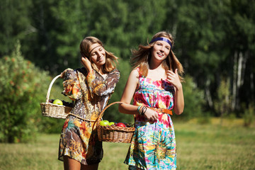 Happy young girls with a fruit basket on nature