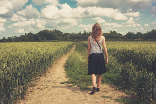 Young woman walking in a wheat field