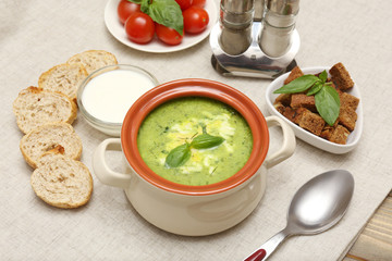 Tasty soup in saucepan on tablecloth, close up