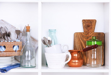 Naklejka na ściany i meble Kitchen utensils and tableware on beautiful white shelves