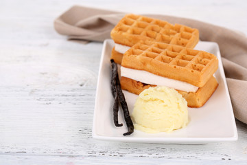 Tasty belgian waffles with ice cream on wooden table