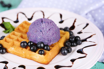 Tasty belgian waffles with ice cream on wooden table