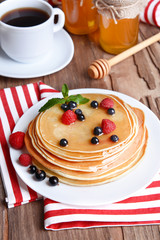 Sweet pancakes with berries on table close-up
