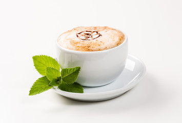 large cup of coffee and green leaf of mint