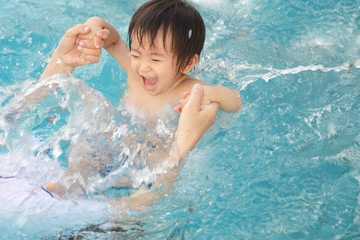Fototapeta na wymiar プールで遊ぶ笑顔の男の子