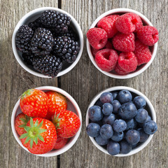 strawberries, blueberries, blackberries and raspberries in bowls