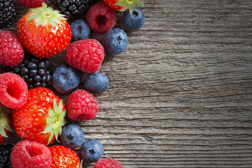 wooden background with fresh berries, top view