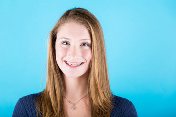 Smiling Beautiful Girl with Braces on Blue Background