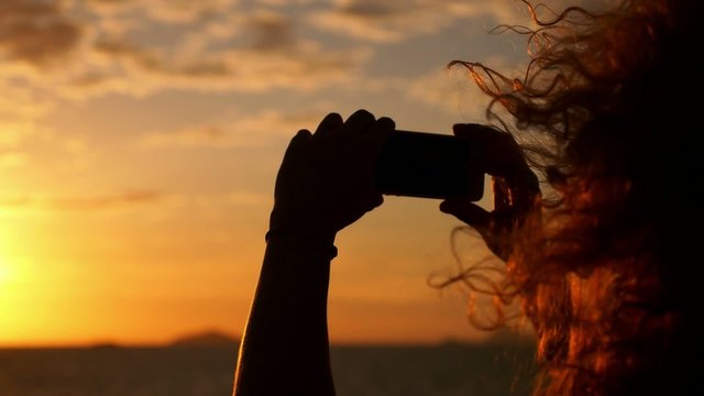 Woman Taking Picture with Smartphone at Sunset in Sea Voyage.