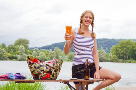 Junge, blonde Frau mit Bier