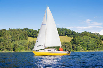Obraz premium Yellow sail boat on the lake