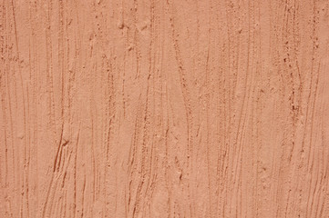 Orange rough plaster on wall closeup in sunny day