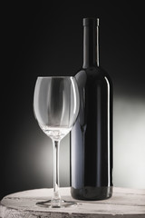 Red wine bottle and wine glass on wodden barrel