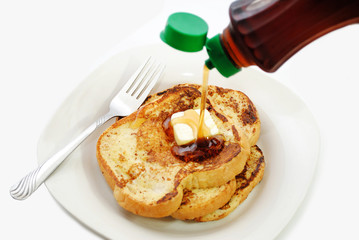 Sweet Maple Syrup Being Poured onto a Plate of French Toast