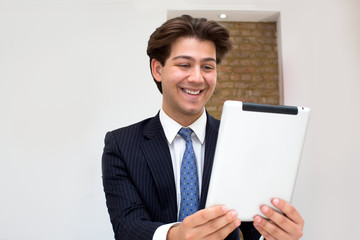 Elated businessman reading good news on a tablet